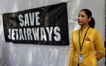 A flight steward of Jet Airways stands next to a banner during a protest demanding to "save Jet Airways" in New Delhi, India, April 18, 2019. REUTERS/Adnan Abidi