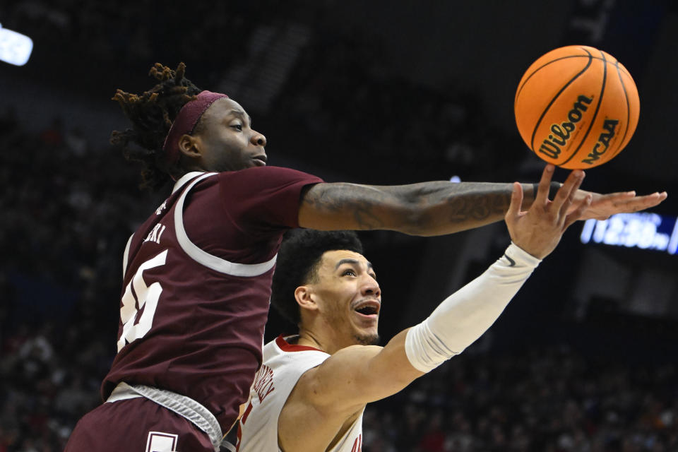 Alabama guard Jahvon Quinerly shoots as Texas A&M guard Manny Obaseki, right, defends during the first half of an NCAA college basketball game in the finals of the Southeastern Conference Tournament, Sunday, March 12, 2023, in Nashville, Tenn. (AP Photo/John Amis)