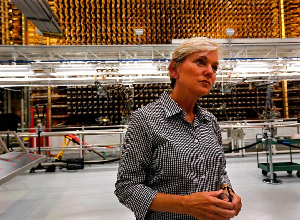 Energy Secretary Jennifer Granholm fields news media questions during her tour of the historic B Reactor Friday on the Hanford site in Eastern Washington. The front of the historic reactor looms behind her.