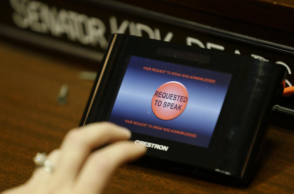 A touch-screen button on a desk in the Washington Senate chamber is tested Thursday, Jan. 5, 2017, in Olympia, Wash. Senators who wish to speak during Senate sessions will push the buttons, which are linked to a braille display, so that Lt. Gov.-elect Cyrus Habib, who is blind, will know by the touch of his finger which lawmaker is seeking to be recognized to speak. Habib, who will preside over the Senate, will be Washington's first blind lieutenant governor, as he replaces Lt. Gov. Brad Owen, who is retiring. (AP Photo/Ted S. Warren)