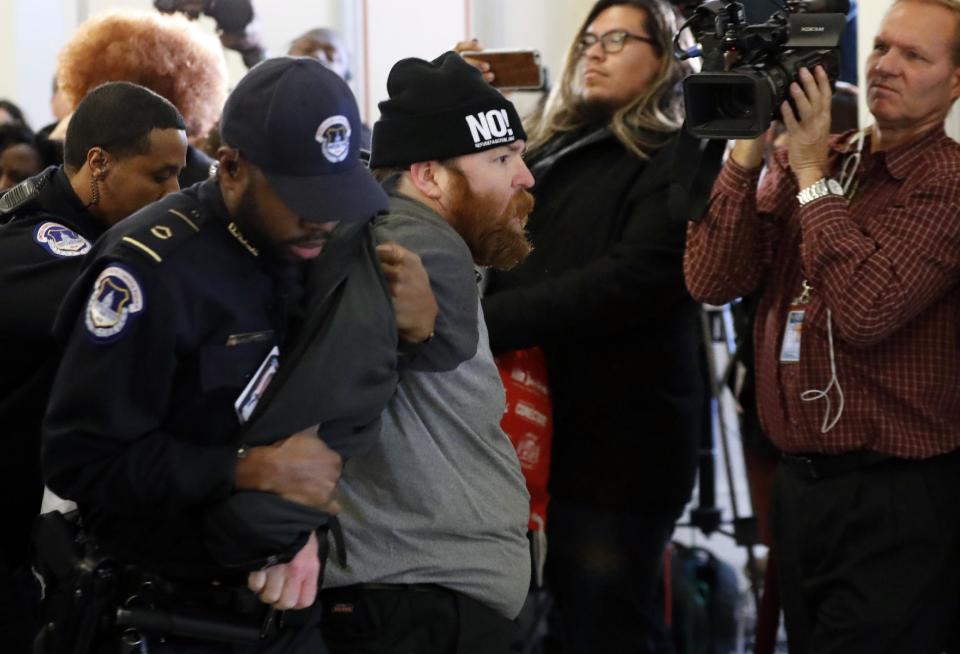 U.S. Capitol Police remove a demonstrator on Capitol Hill in Washington, Tuesday, Jan. 10, 2017, during the Senate Judiciary Committee's confirmation hearing for Attorney General-designate, Sen. Jeff Sessions, R-Ala. (AP Photo/Alex Brandon)