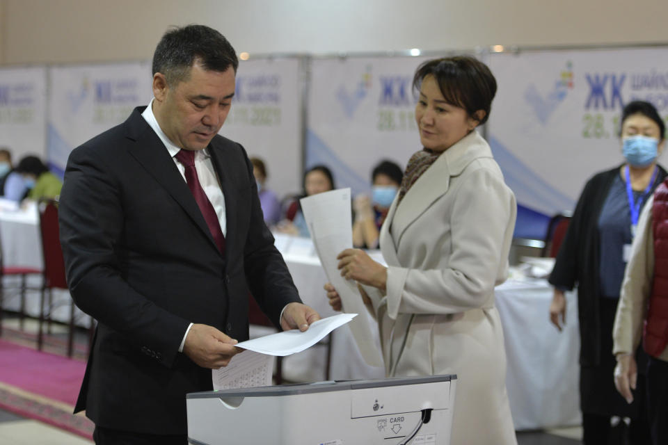 Kyrgyzstan's President Sadyr Zhaparov and his wife Aigul Asanbaeva cast their ballots at a polling station during the parliamentary elections in Bishkek, Kyrgyzstan, Sunday, Nov. 28, 2021. Voters in Kyrgyzstan cast ballots in a parliamentary election Sunday that comes just over a year after a forceful change of government in the ex-Soviet Central Asian nation. (AP Photo/Vladimir Voronin)