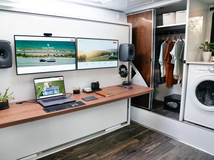 An office space with Apple products like a laptop next to a washer, closet.