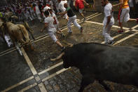 <p>Revellers run next to a fighting bull from the Jose Escolar ranch and a steer during the second day of the running of the bulls at the San Fermin Festival in Pamplona, northern Spain, July 8, 2018. (Photo: Alvaro Barrientos/AP) </p>