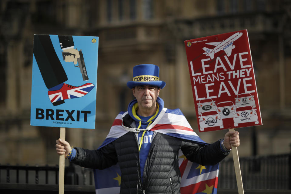 Remain in the European Union supporter Steve Bray, aged 49 from Port Talbot in Wales and who has been protesting for 18-months outside the Houses of Parliament, poses for photographs backdropped by the Houses of Parliament in London, Tuesday, Feb. 12, 2019. Steve believes "Article 50" being revoked, meaning Britain staying in the European Union would be the best way forward. Some demonstrators have been coming to the grounds outside parliament for days, weeks or even months, to make their case as to whether Britain should stay inside the European Union or leave on March 29, as planned. (AP Photo/Matt Dunham)