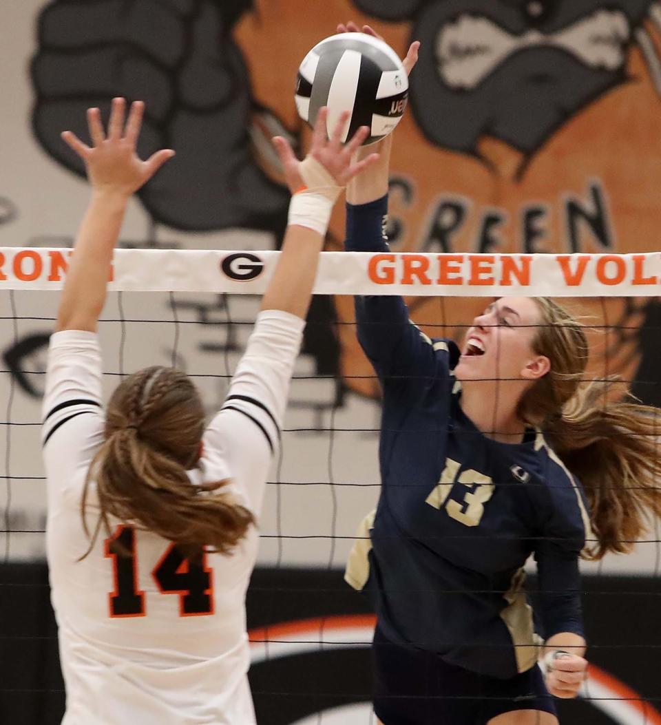 Amber Watson, right, of Hoban slams the ball over for a point past Sydney Peterson of Green during the third set of their match at Green High School Wednesday night. Hoban  won 3 sets to 0. 