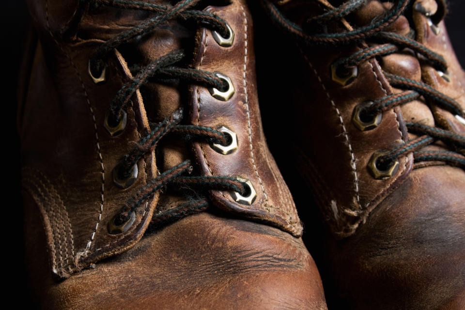 Close-up of worn brown leather boots with laces
