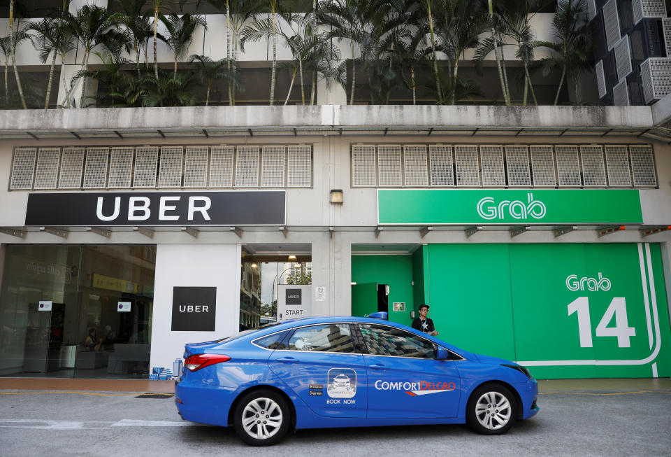 A ComfortDelgro taxi passes Uber and Grab offices in Singapore March 26, 2018. REUTERS/Edgar Su TPX IMAGES OF THE DAY