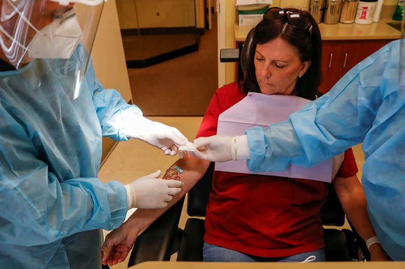 Dr. Vincent Carrao draws blood from a patient for the coronavirus disease (COVID-19) test at Palisades Oral Surgery, in Fort Lee