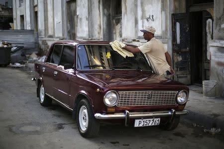 Reynaldo Perez cleans his Lada 1200 built in 1980 on a street in downtown Havana February 7, 2015. REUTERS/Enrique De La Osa