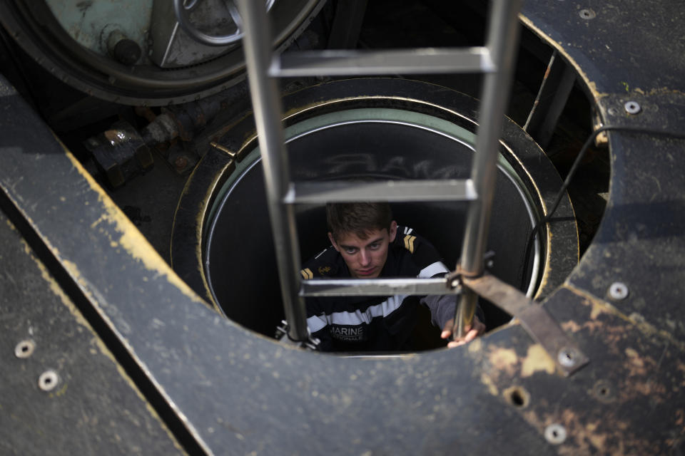 A sailor descends into a French Rubis-class submarine at the Toulon naval base in southern France, Monday, April 15, 2024. The nuclear powered submarine will be guarding France's Charles de Gaulle aircraft carrier during training exercises dubbed Neptune Strike in the Mediterranean with the 32-nation NATO military alliance. (AP Photo/Daniel Cole)