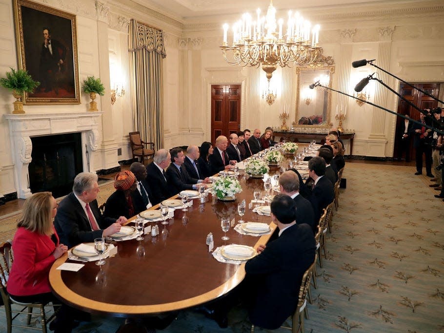 People sit in the State Dining Room in the White House in 2017.