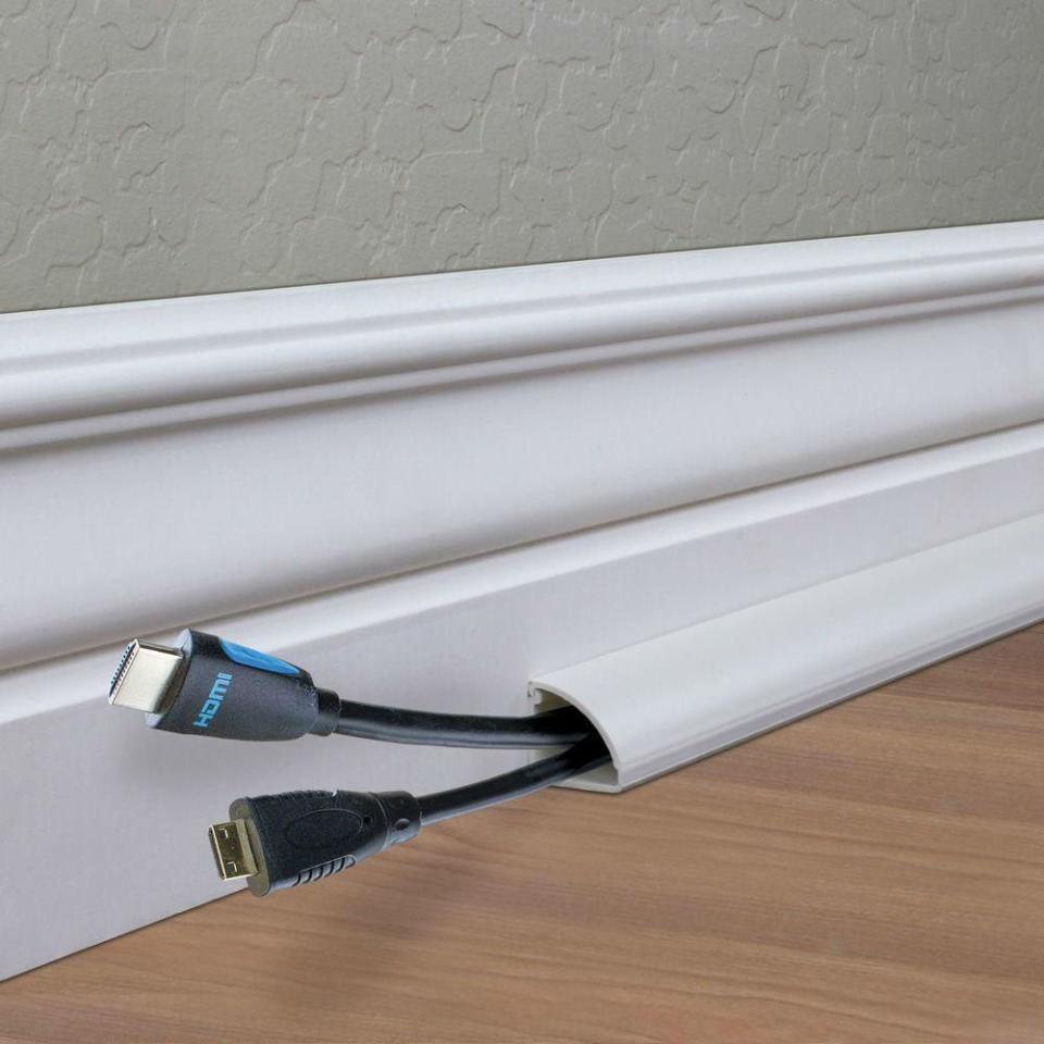 Baseboard cord channels hiding wires against a white baseboard