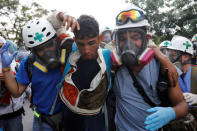 Volunteers help an injured demonstrator (C) during a rally against Venezuela's President Nicolas Maduro in Caracas. REUTERS/Carlos Garcia Rawlins