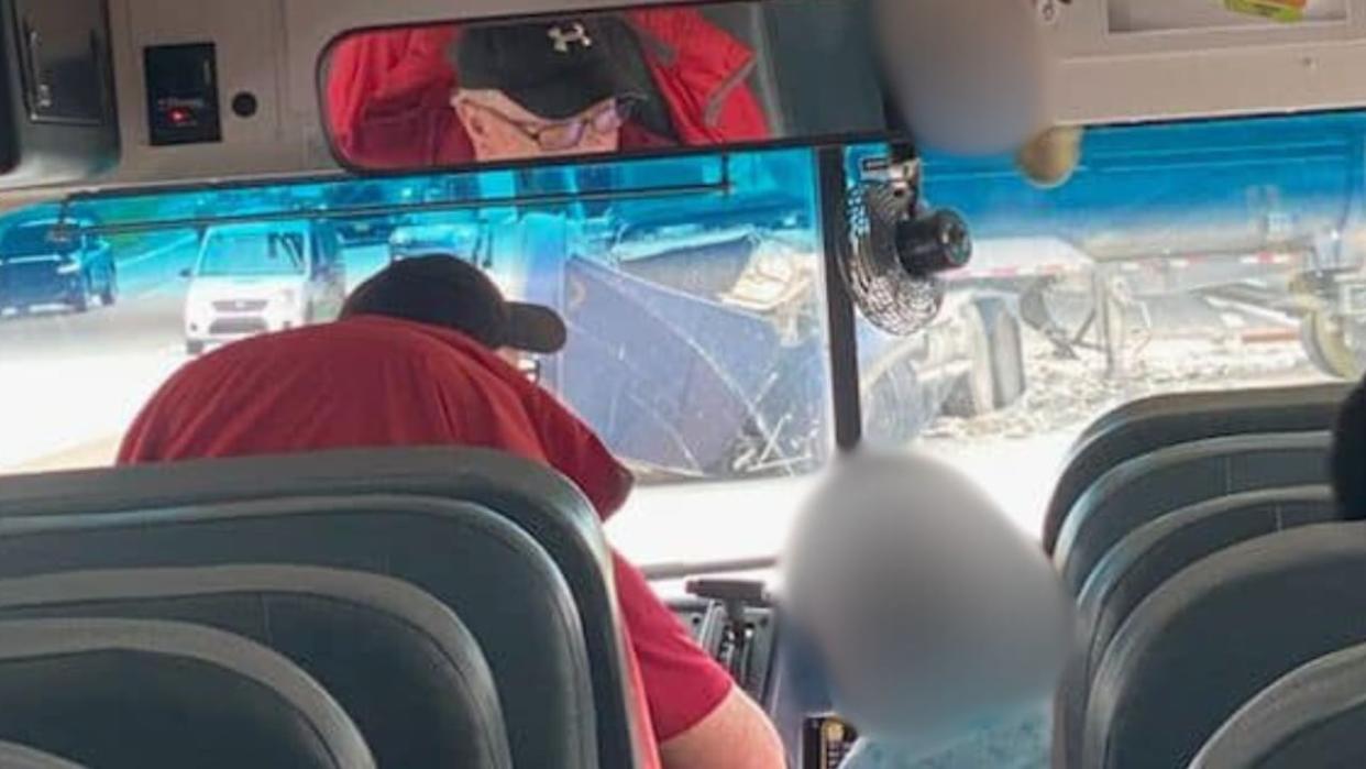 Matthew Baird's stepson was on the bus when the transport truck crashed through a guardrail and landed on Highway 102 near Bedford, N.S. CBC News has blurred the face of the student next to the bus driver to protect their privacy. (Submitted by Matthew Baird - image credit)