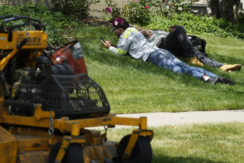 Workers take a break during hot weather in Wheeling, Ill., Monday, June 17, 2024. (AP Photo/Nam Y. Huh)