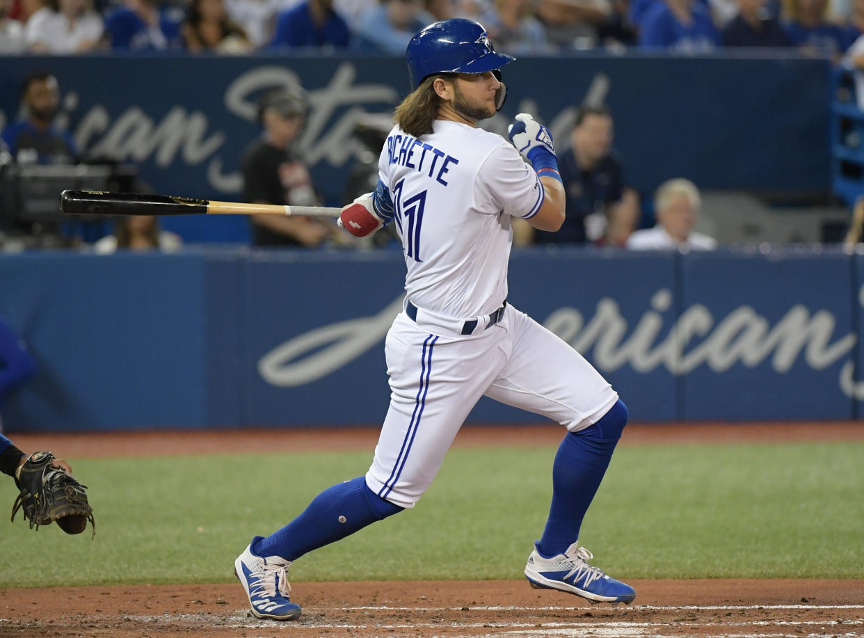 Aug 12, 2019; Toronto, Ontario, CAN;   Toronto Blue Jays shortstop Bo Bichette (11) hits an RBI single against Texas Rangers in the second inning at Rogers Centre. Mandatory Credit: Dan Hamilton-USA TODAY Sports