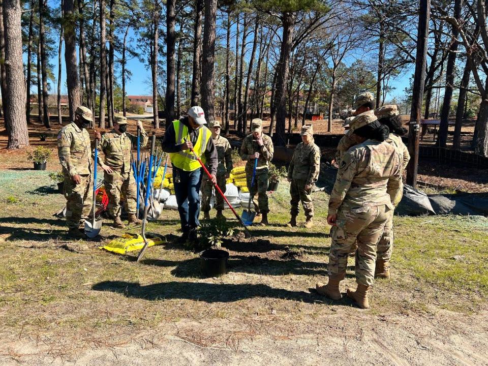 Sharrod Hairston with Fort Bragg Directorate of Public Works, center, gives volunteers instruction on how to plant the new azalea bushes Jan. 19, 2022, at Liberty Park during Fort Bragg's Arbor Day.
