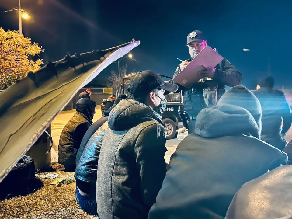 A Juárez police officer interviews migrants found locked in a home on Monday night. The group of 20 migrants included people from Central America, Mexico, Turkey and England.