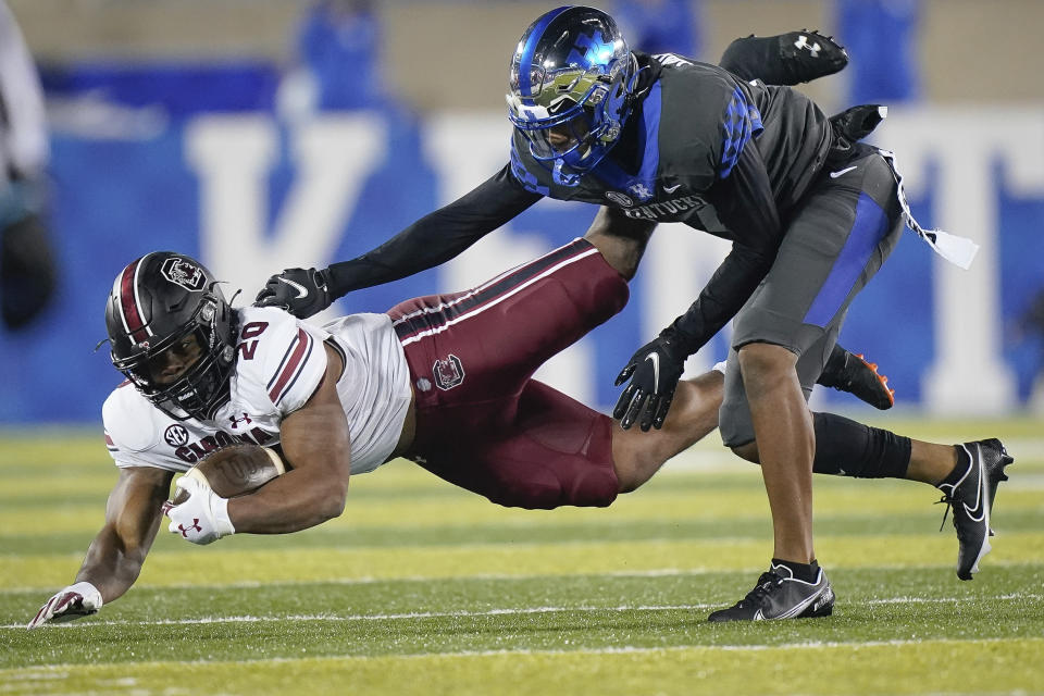 Kentucky defensive back Carrington Valentine (14) tackles South Carolina running back Kevin Harris (20) during the first half of an NCAA college football game Saturday, Dec. 5, 2020, in Lexington, Ky. (AP Photo/Bryan Woolston)