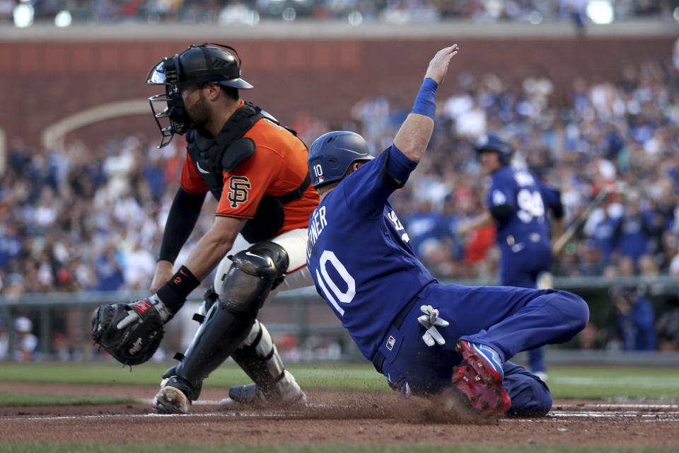 Los Angeles Dodgers' Justin Turner, right, scores on a double by Chris Taylor as San Francisco Giants catcher Curt Casali waits for the throw during the second inning of a baseball game in San Francisco, Friday, June 10, 2022. (AP Photo/Jed Jacobsohn)