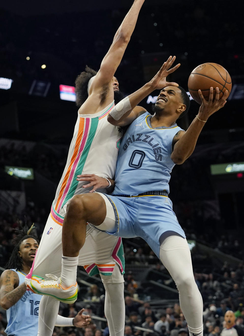 Memphis Grizzlies guard De'Anthony Melton (0) drives to the basket against San Antonio Spurs guard Derrick White (4) during the second half of an NBA basketball game, Wednesday, Jan. 26, 2022, in San Antonio. (AP Photo/Eric Gay)