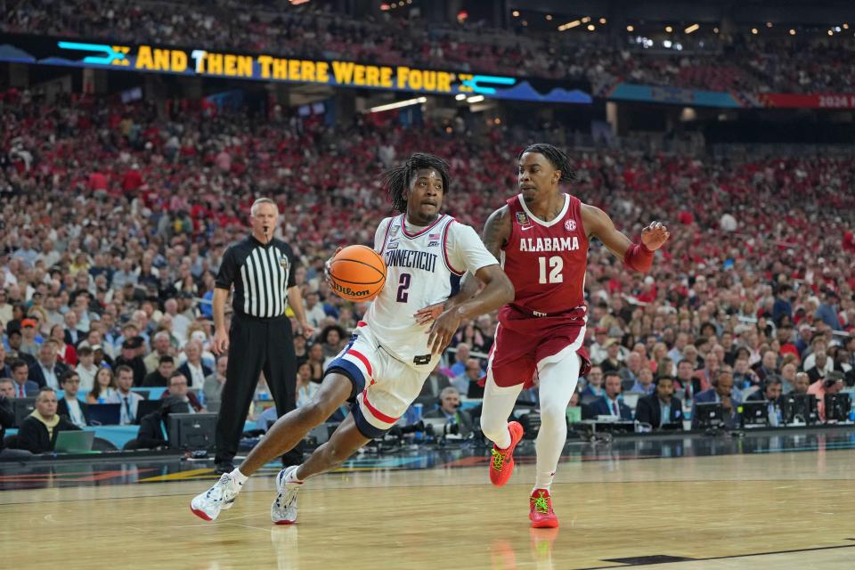 Connecticut guard Tristen Newton (2) dribbles the ball against Alabama guard Latrell Wrightsell Jr. (12) during Final Four of the 2024 NCAA men's tournament at State Farm Stadium.