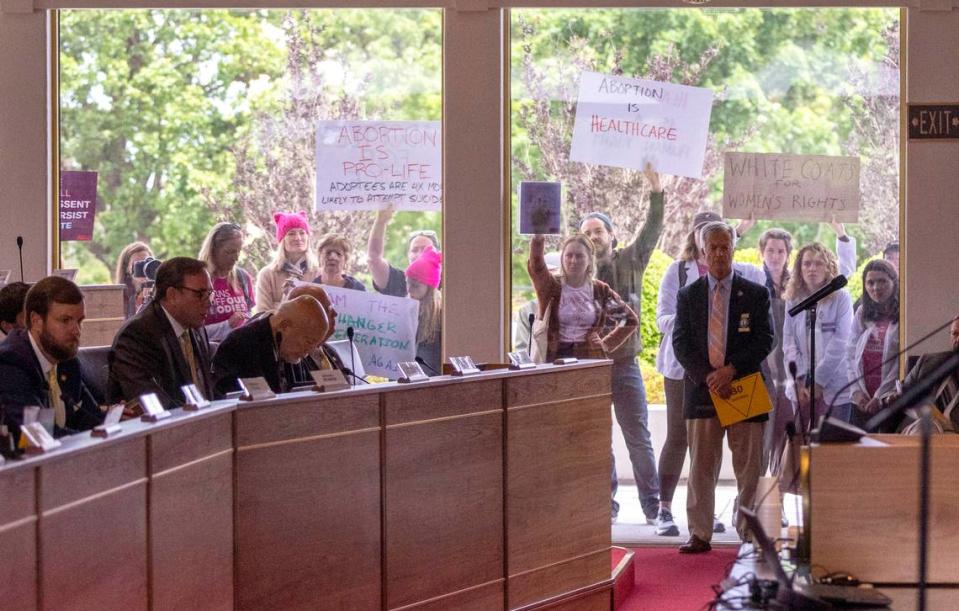 Demonstrators hold signs outside the legislature auditorium where a House Rules meeting was underway, May 3, 2023 at the Legislative Building. Republican state lawmakers announced their plan to limit abortion rights across the state.