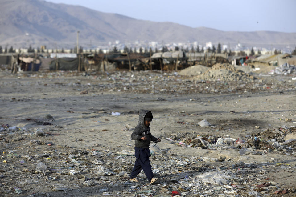 An internally displaced boy walks outside his temporary home in the city of Kabul, Afghanistan, Monday, Jan. 18, 2021. Half of war-ravaged Afghanistan’s population is at risk of not having enough food to eat, including around 10 million children, Save the Children, a humanitarian organization said Tuesday. The group called for $3 billion in donations to pay for assistance in 2021. (AP Photo/Rahmat Gul)