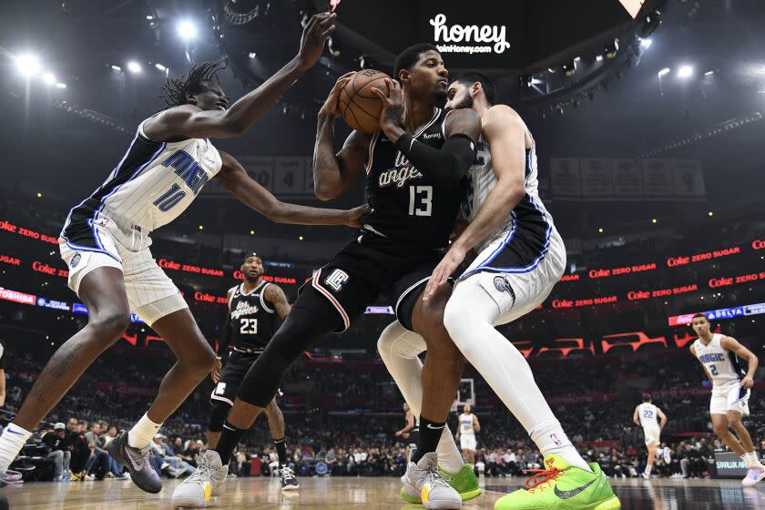 LOS ANGELES, CA - MARCH 18: Paul George #13 of the Los Angeles Clippers is double teamed by Bol Bol.