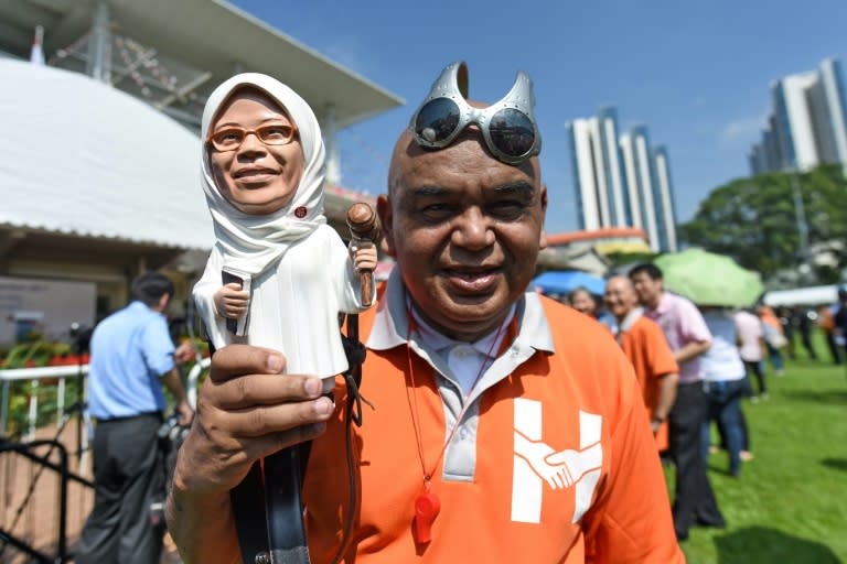 A supporter displays a figurine of former parliamentary speaker Halimah Yacob, who has been named the country's new president