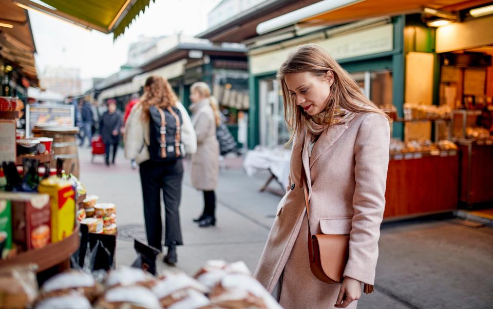 Austria, Vienna, woman looking at an offer at Naschmarkt