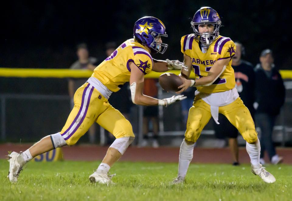 Farmington running back Jack Wheelwright (6) takes a handoff from his brother, and quarterback, Lane Wheelwright in the second half of their varsity football game Friday, Sept. 22, 2023 in Farmington. The Farmers defeated the Trojans 30-26.