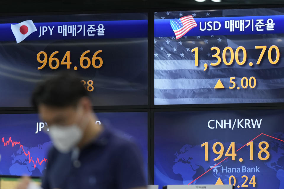 A currency trader walks near the screens showing the foreign exchange rates at a foreign exchange dealing room in Seoul, South Korea, Friday, June 24, 2022. Shares were higher in Asia on Friday, tracking gains on Wall Street, where the market is headed for its first weekly gain after three weeks of punishing losses. (AP Photo/Lee Jin-man)