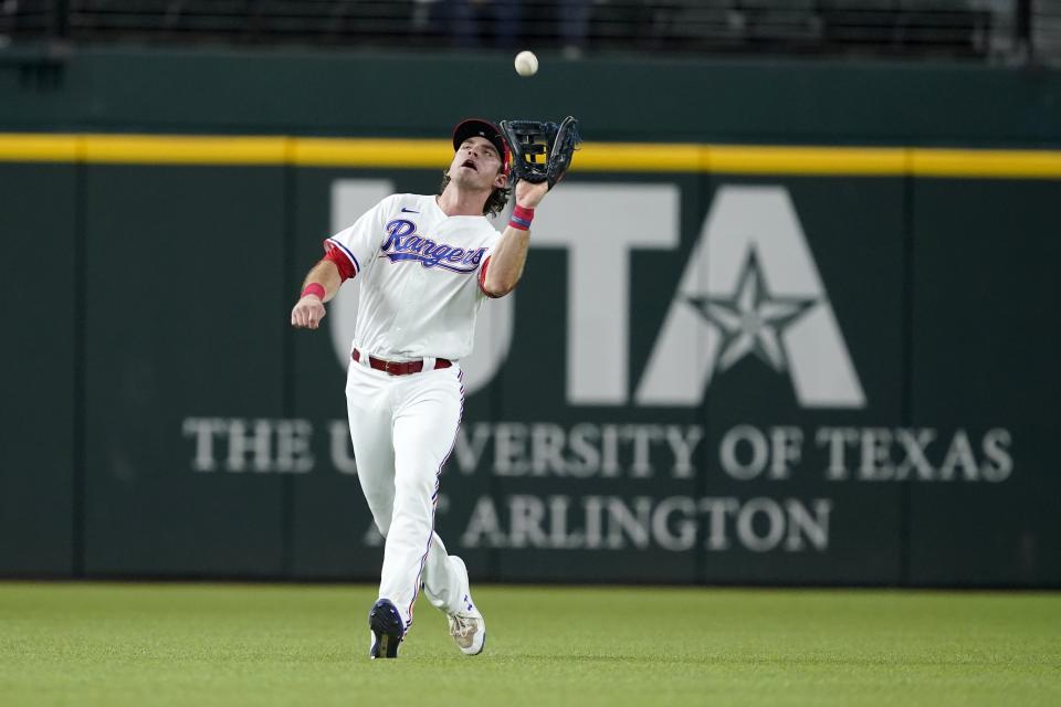 Texas Rangers left fielder DJ Peters reaches up to catch a fly out by Los Angeles Angels' Jared Walsh in the sixth inning of a baseball game in Arlington, Texas, Tuesday, Sept. 28, 2021. (AP Photo/Tony Gutierrez)