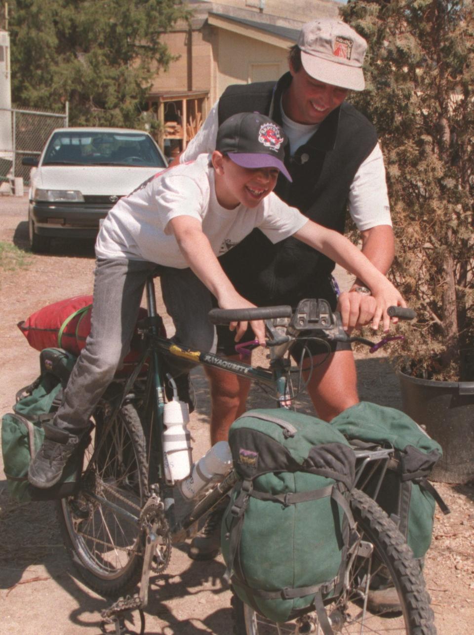 man helping son ride bike