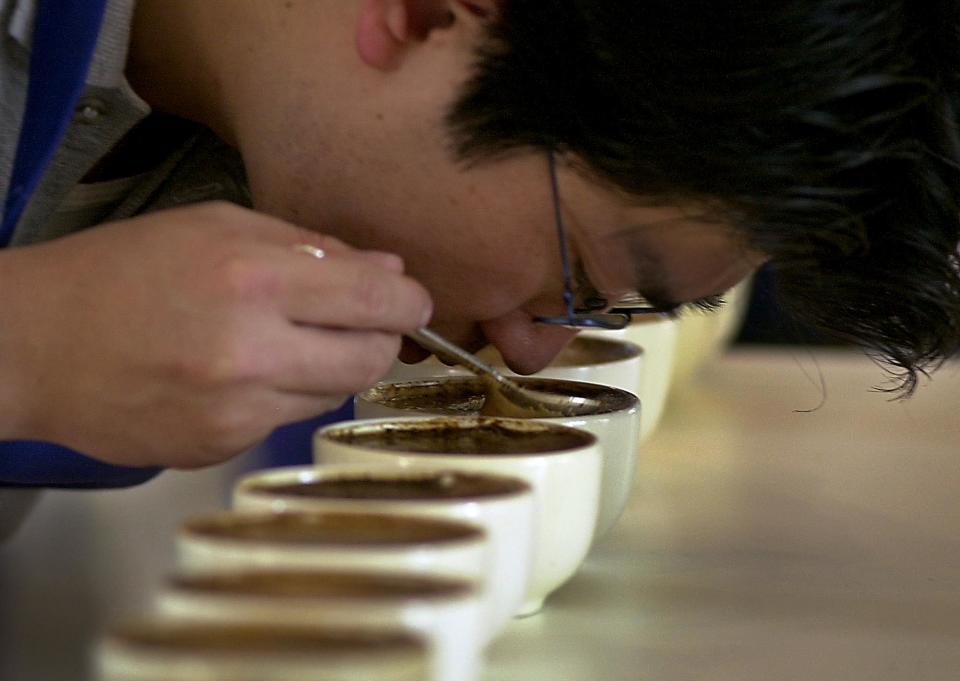 FILE - In this Wednesday, April 30, 2003 file photo, Yoshi Kato tests coffee for aroma, texture and taste during a contest of Nicaraguan coffee growers in Managua, Nicaragua. A large U.S. federal study concludes people who drink coffee seem to live a little longer. Researchers saw a clear connection between cups consumed and years of life. Whether it was regular or decaf didn't matter. The results are published in the Thursday, May 17, 2012 New England Journal of Medicine. (AP Photo/Esteban Felix)