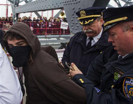 New York Police Department officers detain an Occupy Wall Street activist during a protest march across the Williamsburg Bridge in New York in this May 1, 2012, file photo. REUTERS/Lucas Jackson/Files