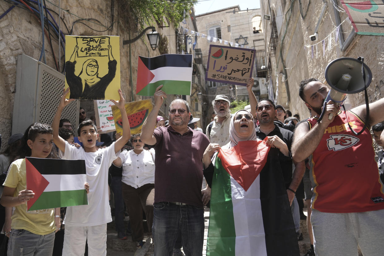 Israeli lawmaker Ofer Cassif, center, holds a representation of a Palestinian flag during a protest against the imminent eviction of Nora, second right, and Mustafa Ghaith-Sub Laban and their family by a Jewish settler organization, outside of their home in the Old City of Jerusalem, Friday, June 16, 2023. (AP Photo/Mahmoud Illean)