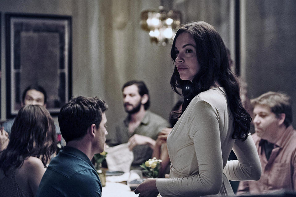 A woman looks around pensively during a dinner party