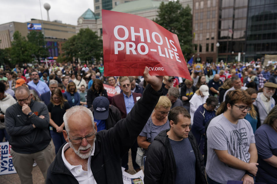 Paul Meacham holds high a sign that reads "Ohio is pro-life" as the crowd prays during the Ohio March for Life rally at the Ohio State House in Columbus, Ohio, Friday, Oct. 6, 2023. "I'm a believer in Jesus Chris and every life has a purpose," Meacham said. As campaigning escalates in Ohio’s fall fight over abortion rights, a new line of attack from opponents suggests “partial-birth” abortions would be revived if a proposed constitutional amendment passes. (AP Photo/Carolyn Kaster)