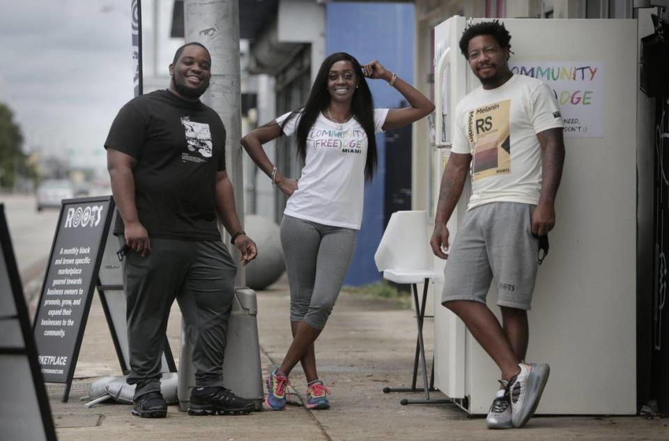 Isaiah Thomas, left, Sherina Jones and Danny Agnew by the refrigerator they placed in front of the Roots Collective to provide free food to locals.