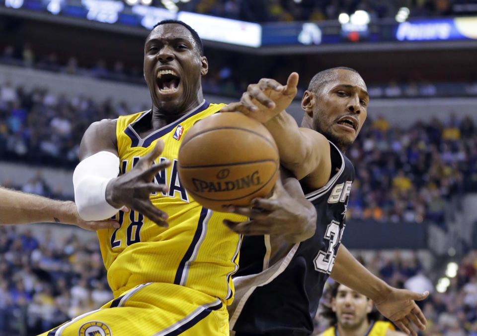 Indiana Pacers center Ian Mahinmi, left, and San Antonio Spurs forward Boris Diaw battle for rebound in the first half of an NBA basketball game in Indianapolis, Monday, March 31, 2014. (AP Photo/Michael Conroy)