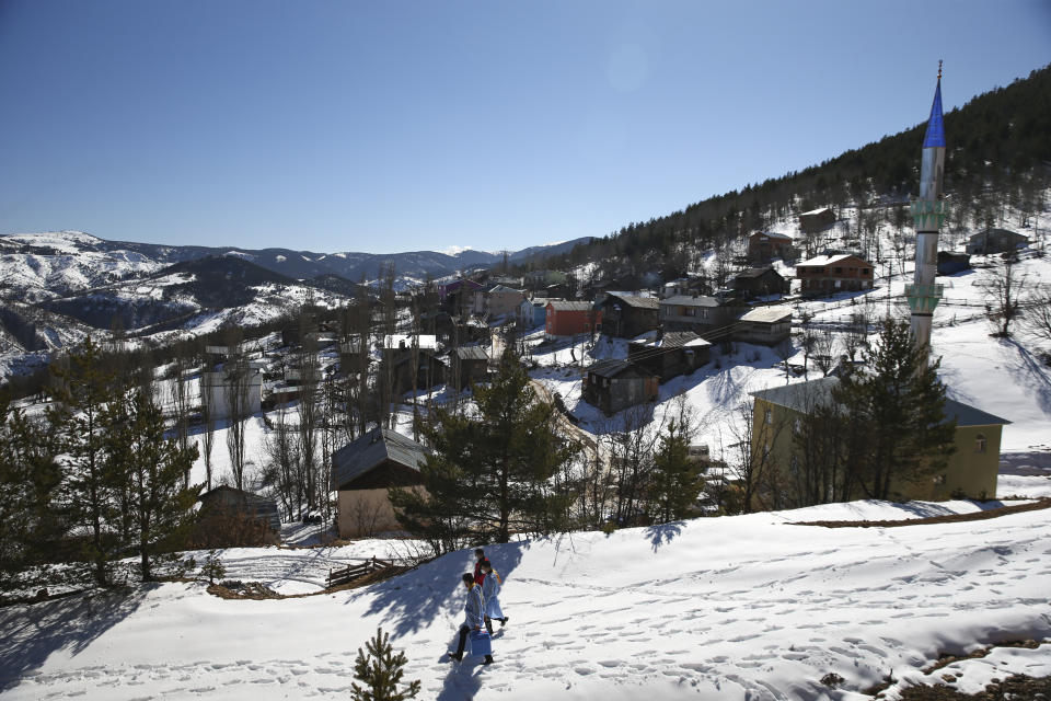 Doctors and health workers of a COVID-19 vaccination team walk through the isolated village of Gumuslu in the district of Sivas, central Turkey, Friday, Feb. 26, 2021. (AP Photo/Emrah Gurel)