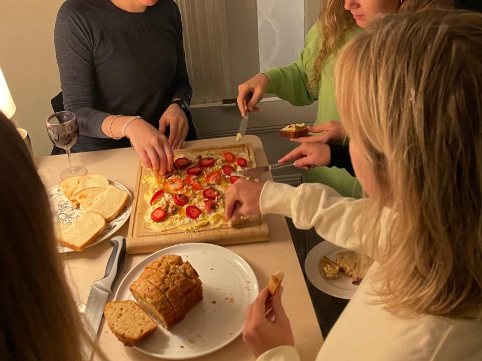 people reaching towards a butter board