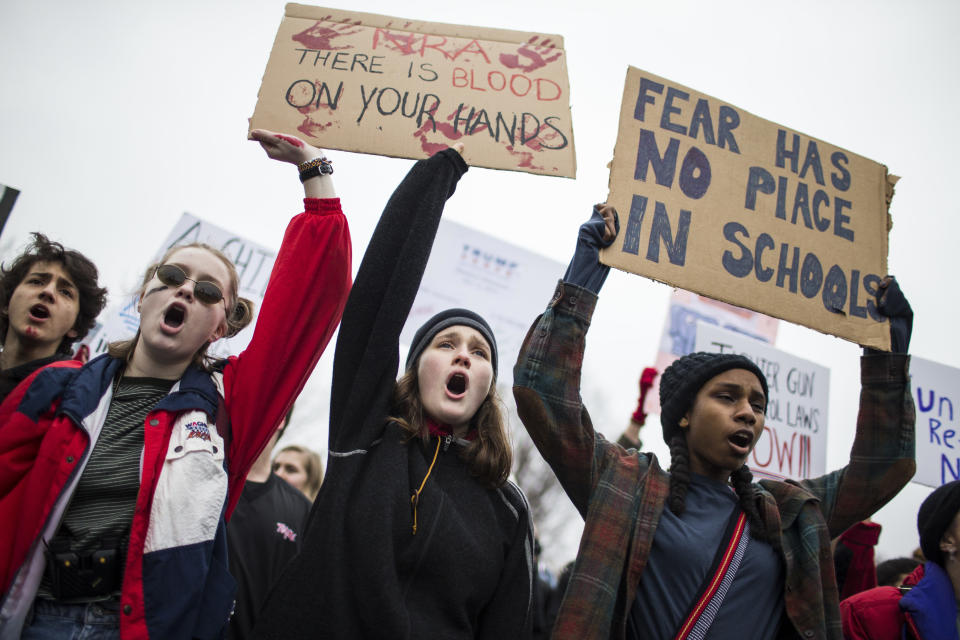 Protesters hold signs during the demonstration against gun violence. (Photo: Zach Gibson/Getty Images)