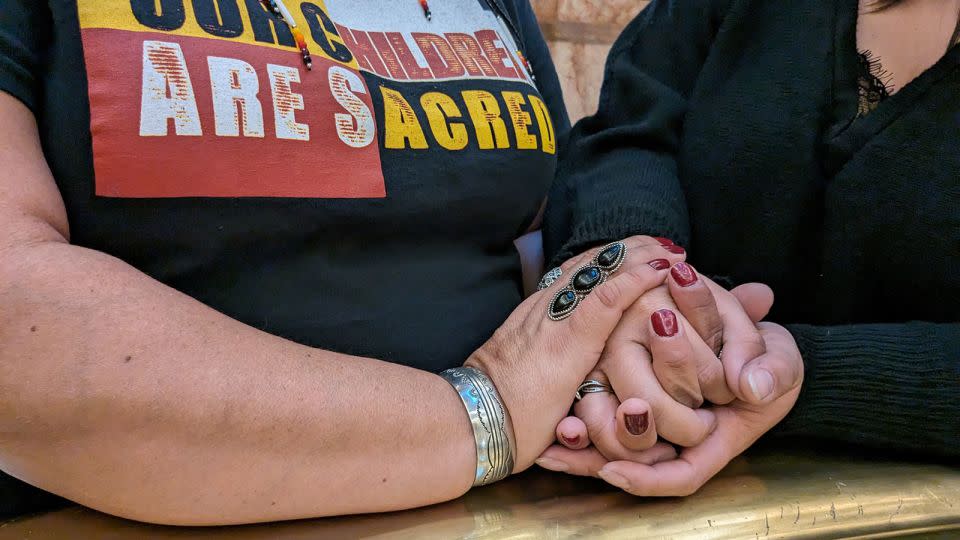 Gavinn McKinney's mother and one of his sisters hold hands after a committee hearing at the Colorado state Capitol. - Rae Ellen Bichell/KFF Health News