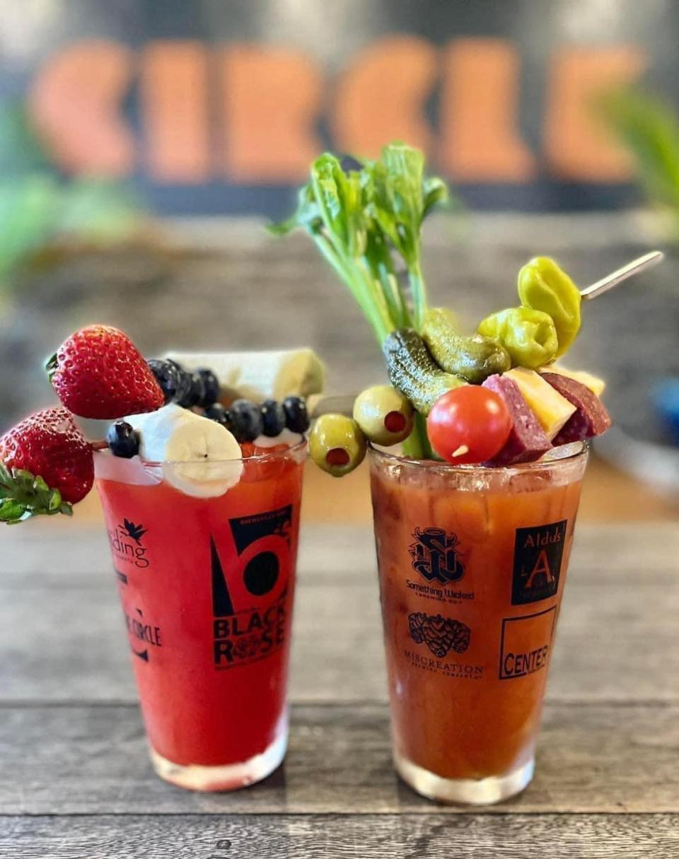 Fruity Bloody cocktail (left) is made with Strawberry banana V8, blueberry vodka, garnished with fresh banana, strawberries, and blackberries on top