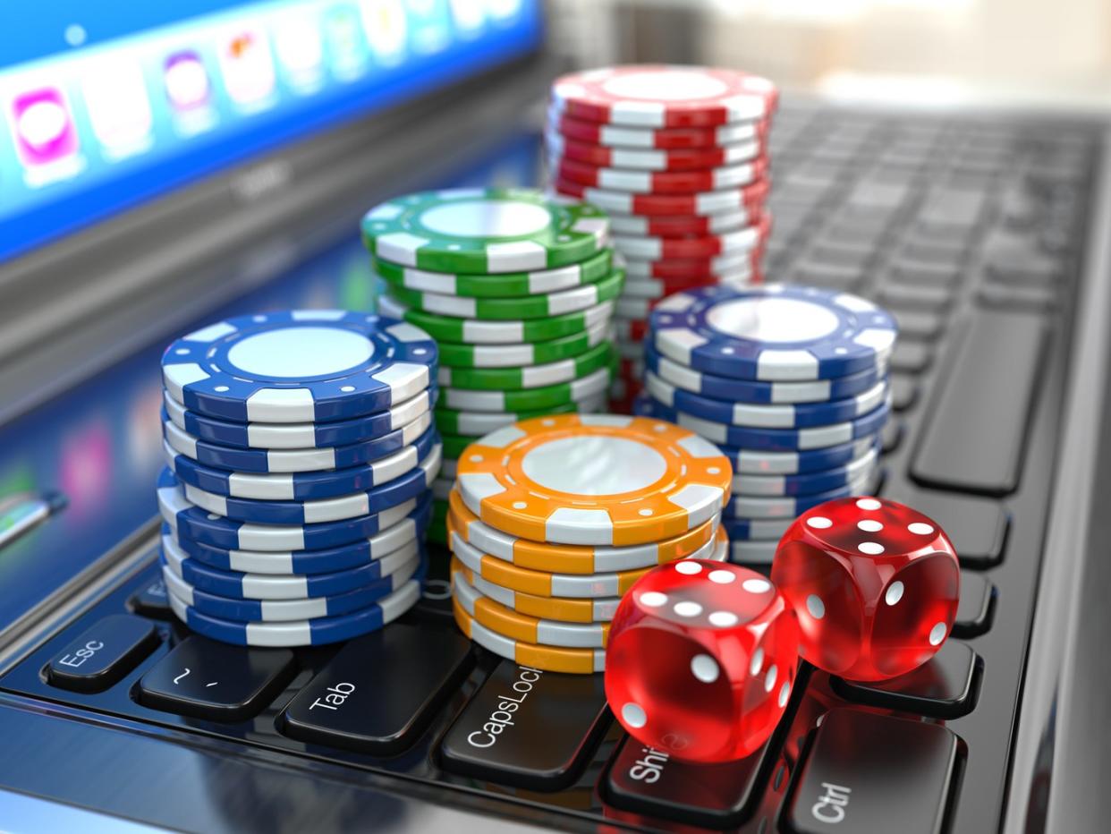 Casino chips and dice on laptop keyboard
