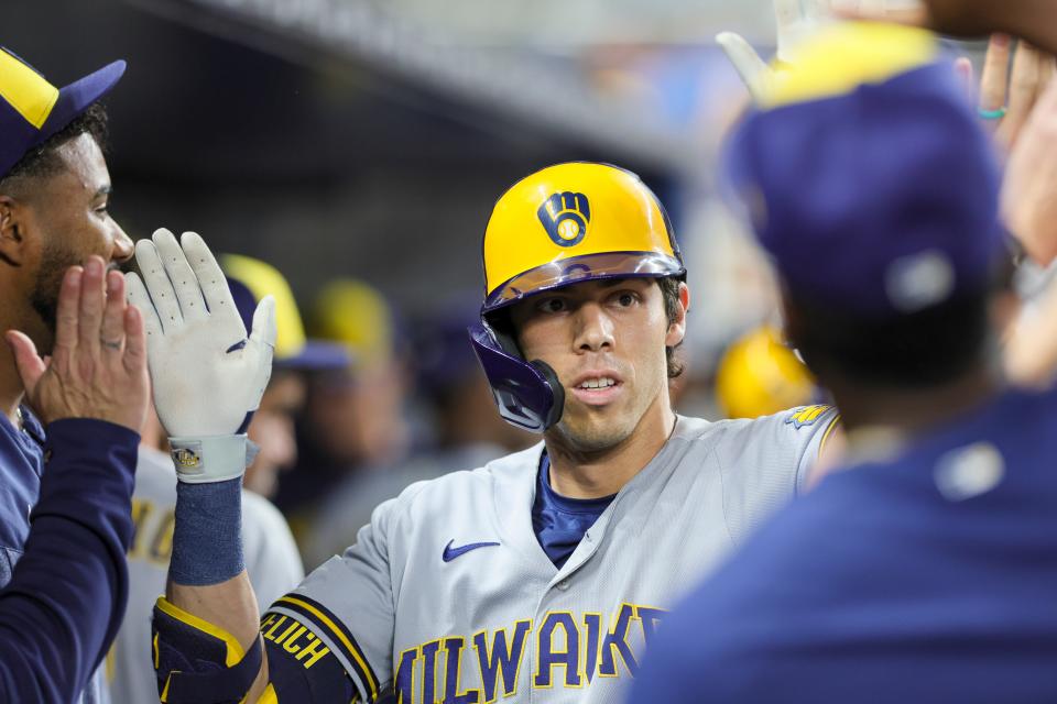 Christian Yelich is congratulated by teammates in the dugout after hitting a two-run homer to cap the Brewers' 12-run second inning against the Marlins on Friday night. Yelich added a three-run shot in the sixth inning.